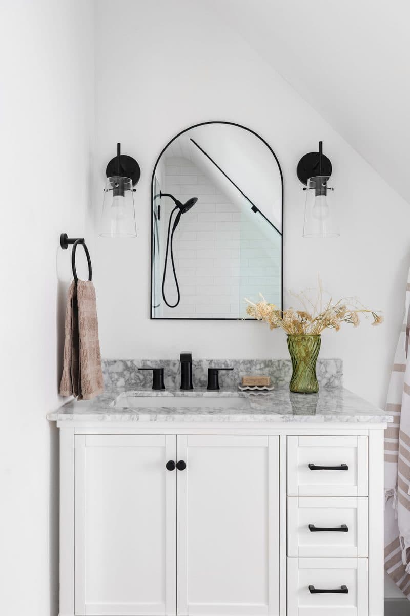 Renovated bathroom with arch mirror and marble vanity — Denver bathroom remodel