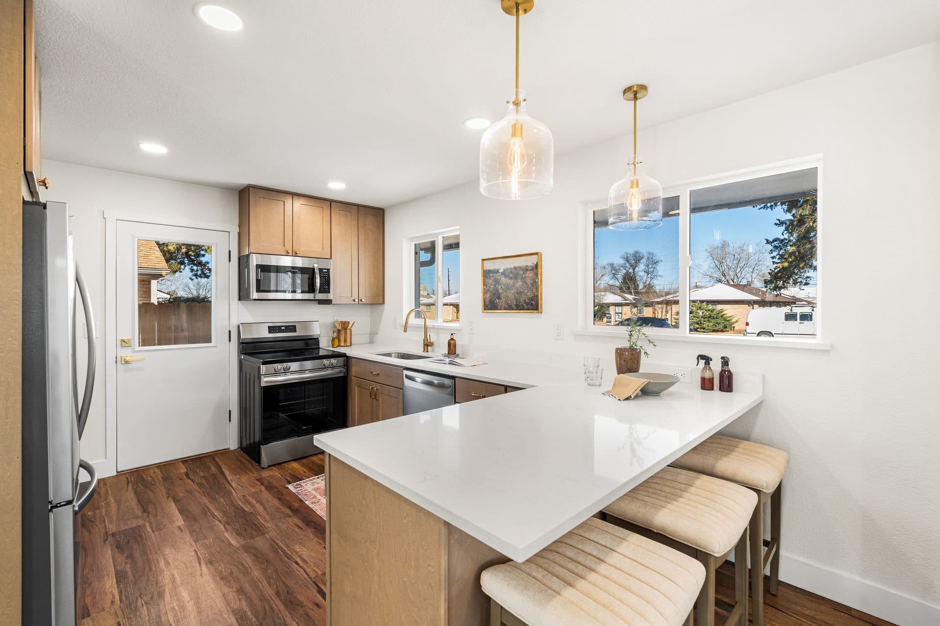 Renovated kitchen with island and gold pendant lights — Denver kitchen remodel